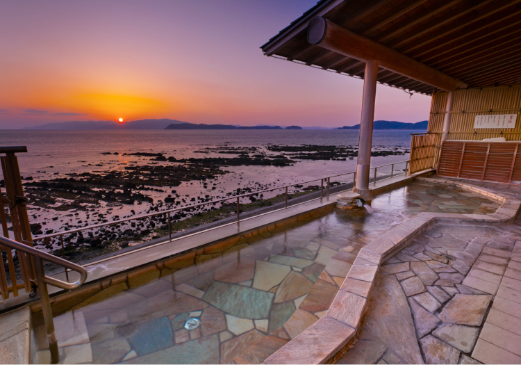 美人の湯の露天風呂から見る夕陽の絶景。海沿いならではの非現実を演出します。
