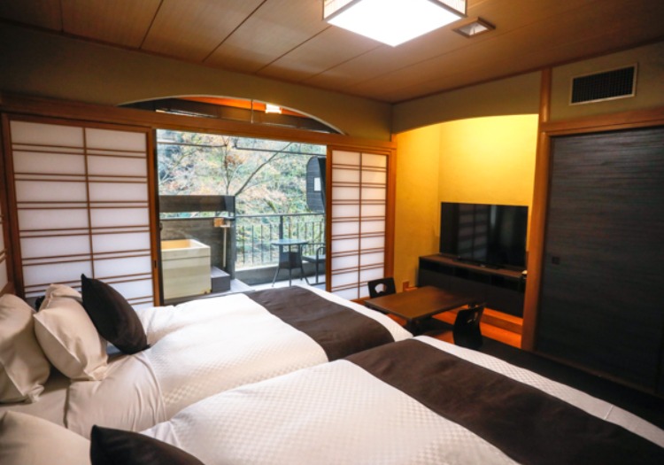 和の趣とモダンが融合した客室。プライベートな露天風呂で至高の寛ぎを提供します。