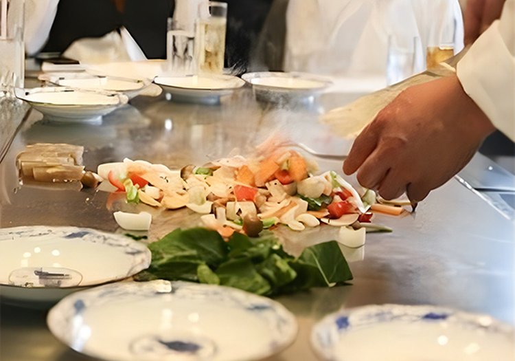 鉄板焼きの臨場感あふれる調理シーン。お客様の目の前で腕を振るう人気のお仕事です