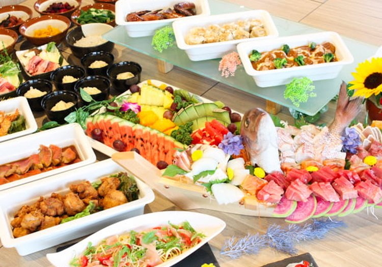 夏のビュッフェ会場。西瓜カットや刺身舟盛りなど季節感ある料理を演出いただきます