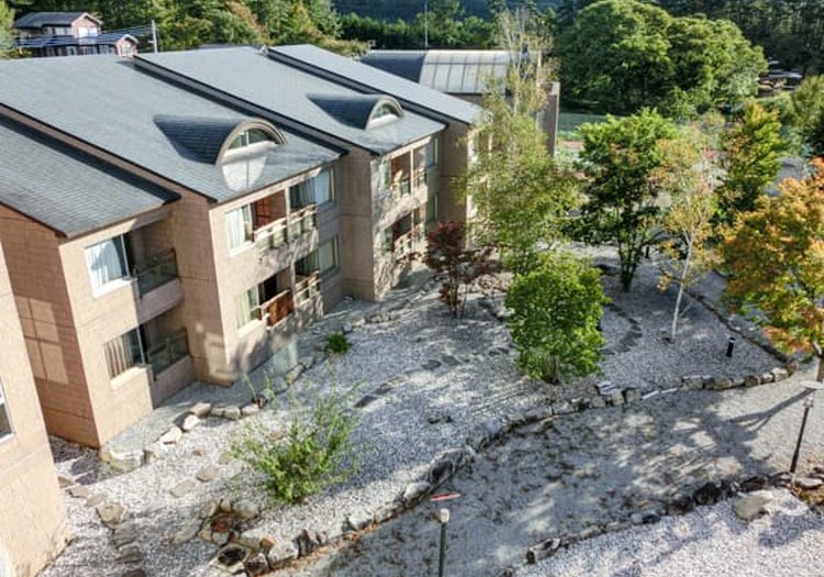 空撮で見るコテージ風の建物群。高原の自然と調和したリゾートで料理を担当します
