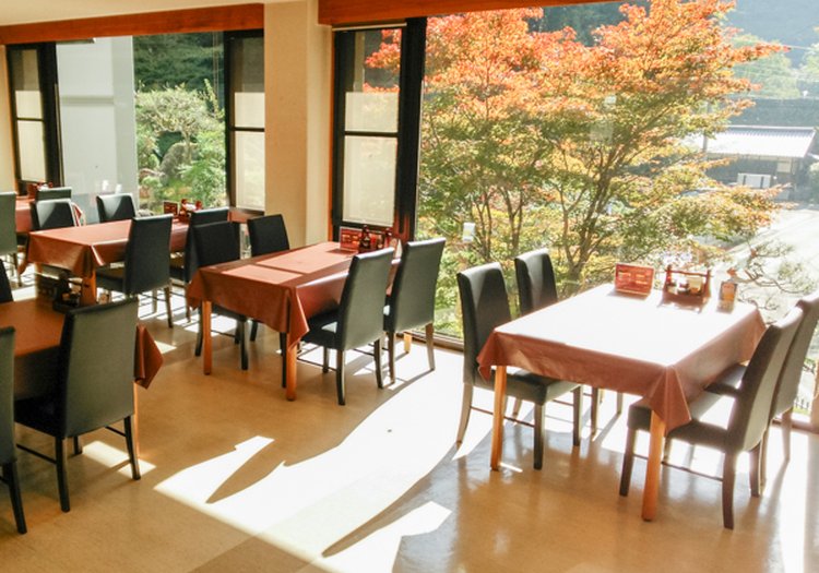 紅葉が見える窓のあるレストラン。四季の彩りとともに料理を提供する人気の宿です