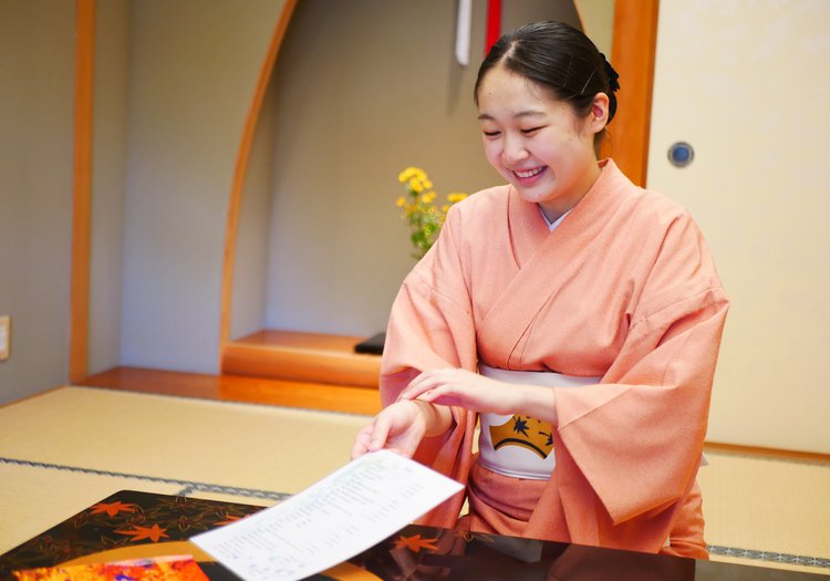客室でお客様を笑顔でお迎えする仲居。心のこもったおもてなしを大切にしています