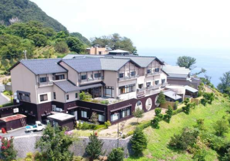 美肌の湯でくつろぎながら、日本海の絶景を堪能できる温泉宿 「奥伊根温泉 油屋本館」は全23室、伊根町の中では規模の大きな宿で、重要伝統的建造物群保存地区の建造物や、日本三景の景勝地など、周辺地域の観光拠点として幅広くご利用いただいています。日本海を見下ろす高台に位置し、雄大な景観と温かいおもてなしが当館の自慢。近海で水揚げされる豊富な海の幸を使ったお料理はもちろん、自家掘りの天然温泉はツルツル・スベスベな肌触りで、美肌の湯としてお客様から好評です。本館と同じ場所に全11室の別館「和亭」、伊根の舟屋エリアに飲食店5店舗、宿泊施設2店舗もございます。