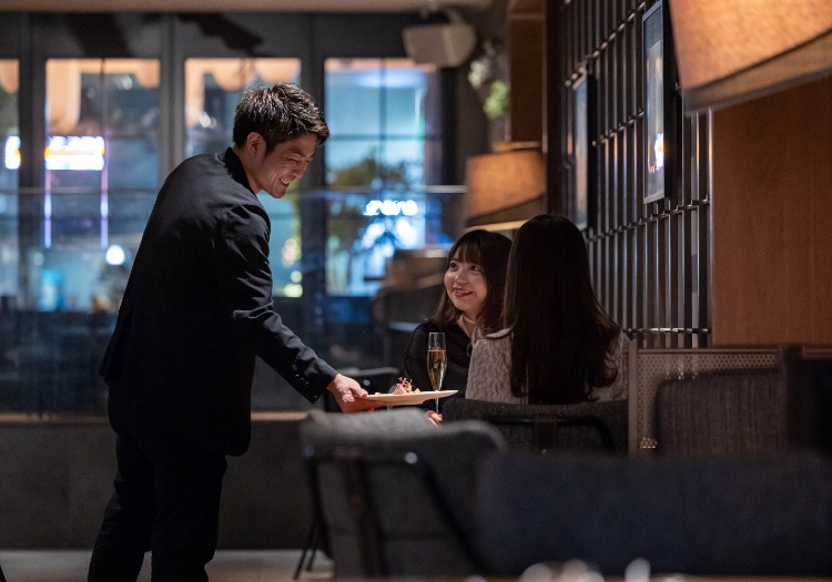 等身大のホスピタリティ。マニュアルを超えた「一人ひとり」への心遣い 私たちのサービスには、決まりきったマニュアルはありません。大切にしているのは、お客様一人ひとりの期待に合わせた「等身大のホスピタリティ」です。例えば、お誕生日のお客様にサプライズを企画したり、小さなお子様が食べやすいように食材のカット方法を工夫したりと、大切な家族や友人に接するように働くことを称賛する風土があります。スタッフ自身が楽しみながら、自分自身のホスピタリティマインドをミックスさせた接客を行なうことで、お客様にとってもスタッフにとっても、活力ある豊かな明日を作り上げています。