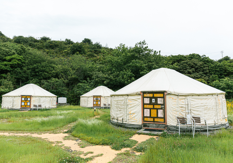 3タイプの宿泊棟！豊かな自然とアクティビティを満喫 「直島町ふるさと海の家つつじ荘」は海辺の国立公園に面し、館内から美しい瀬戸内海が望める施設です。開業以来、町民の皆様から「ふるさとの海の家」として愛されています。シティホテルのように完成された便利さはありませんが、ほどよい「足りなさ」が島らしさを体現し、その非日常感が島外のお客様からもご好評！「泊まれる海の公園」をコンセプトに、お部屋はモンゴルのテントであるパオ、和室コテージ、トレーラーハウスの3タイプからお選びいただけます。BBQや海水浴、花火など、多彩なアクティビティも満喫できます。