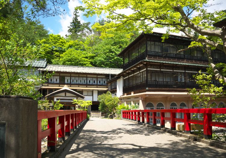 元禄時代から続く歴史ある旅館。本館前にかかる赤い橋はシンボルの一つです