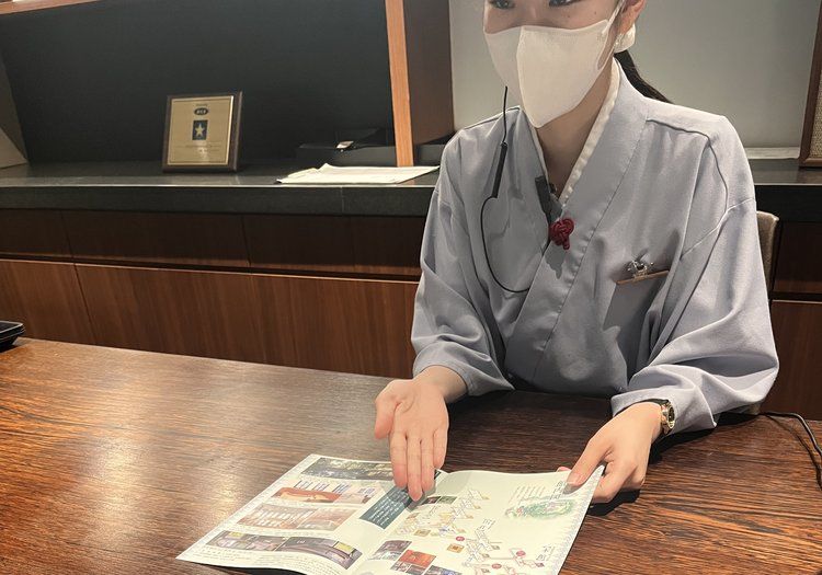 館内マップを広げて過ごし方をご案内。周辺の楽しみ方までお伝えする役割です。