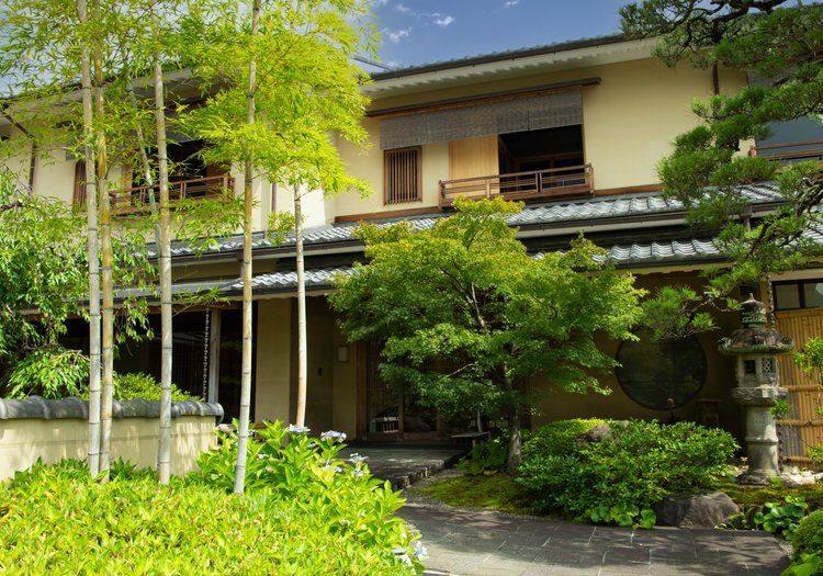 嵐山の豊かな緑に包まれた料理旅館の外観。落ち着いた和の佇まいが日々の仕事場になります
