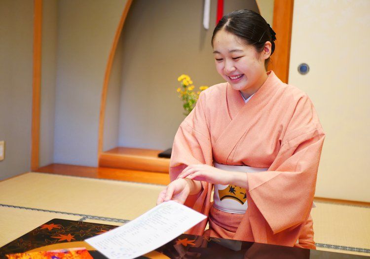客室でお客様を笑顔でお迎えする仲居。心のこもったおもてなしを大切にしています