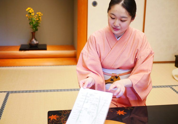着物姿でお品書きをご説明する仲居。お客様に寄り添う丁寧な接客のひとこまです