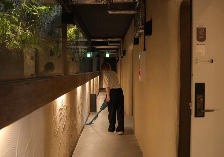 客室フロアの廊下を清掃中。館内清掃も、チームで分担しながら進めています。