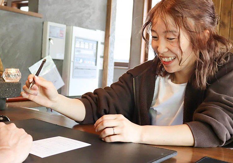 フロントでのゲスト対応。現場に立ちながら、施設全体のサービスに目を配ります。